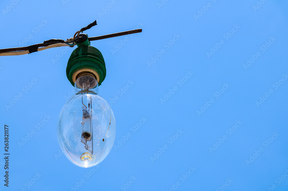 Eelectrical light bulb on blue sky background, electric lamp on blue background, Lightbulbs hang in the air