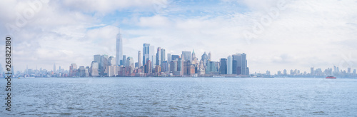 Panoramic cityscape of Lower Manhattan with 1 World Trade Center, Freedom Tower, and other skyscrapers under a dramatic sky