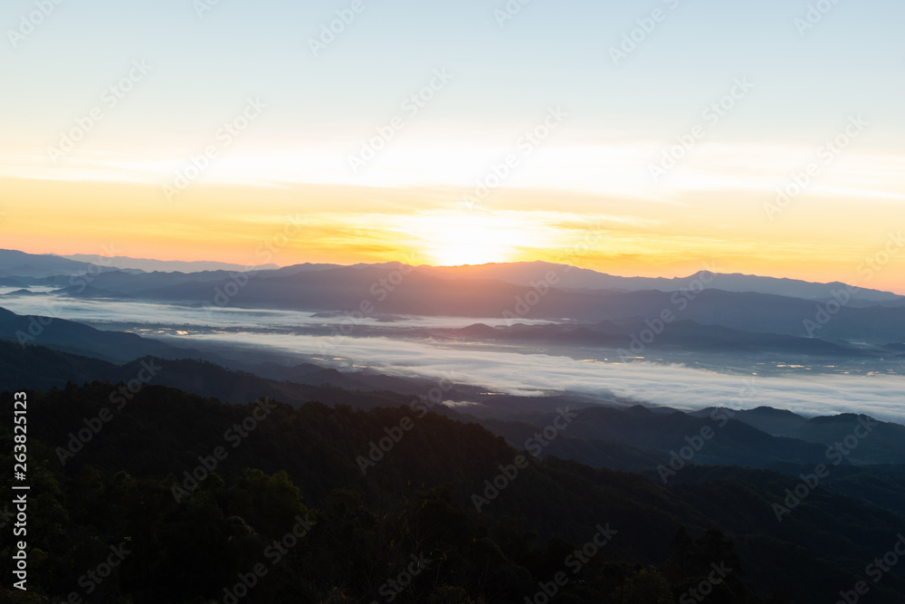 The view of the sunrise on the mountain in cold weather with fog in the mountains