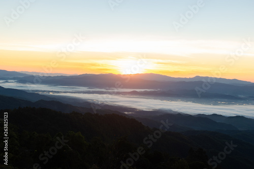 The view of the sunrise on the mountain in cold weather with fog in the mountains