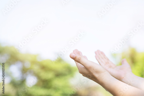 Close up of Christian man with praying open hands worship christian reaching for the sky and green blur leaf bokeh for blessing from god in the morning. concept for faith, spirituality and religion. 