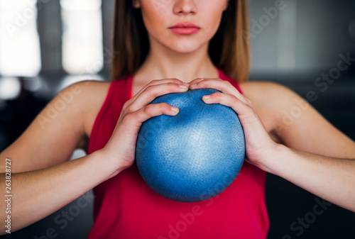 Amidsection of young girl or woman doing exercise with a ball in a gym.