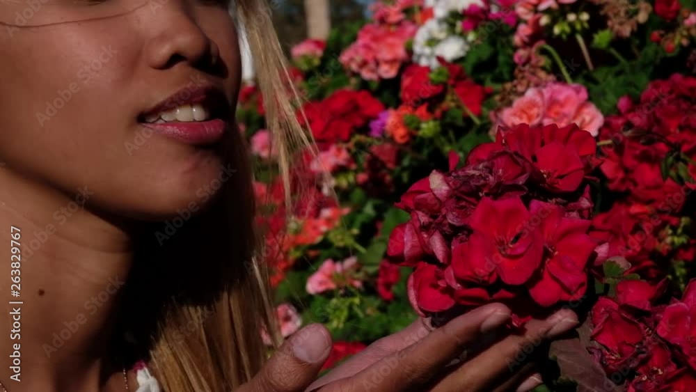 Young Asian girl passes and smells flowers on her walk. Young Asian girl passes and smells flowers on her walk.