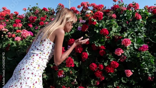 Asian girl smells red Crane's-bill flowers. photo