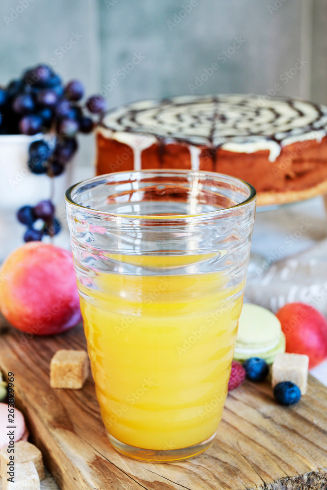 Orange juice glass among various fruits.