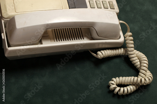 vintage phone with handset and answering machine on green velvet,the handset lies next