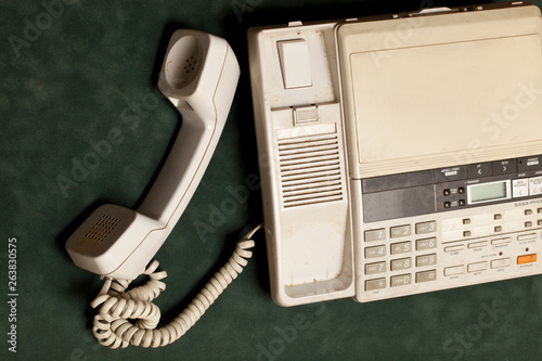 vintage phone with handset and answering machine on green velvet,the handset lies next