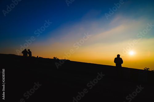 Silhouette of man on top of mountain, The silhouette of the photographer stands in the morning., Shadow tourists are watching the sunset on the mountain.
