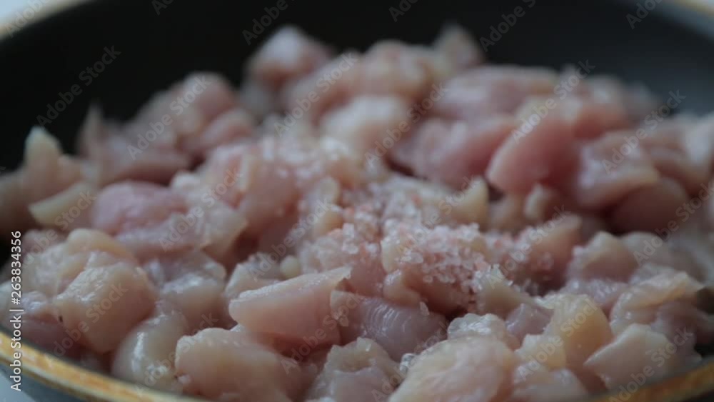 Chicken cut into cubes for cooking. Chicken fillet in a frying pan with butter. Chicken cut into cubes for cooking. Chicken fillet in a frying pan with butter.