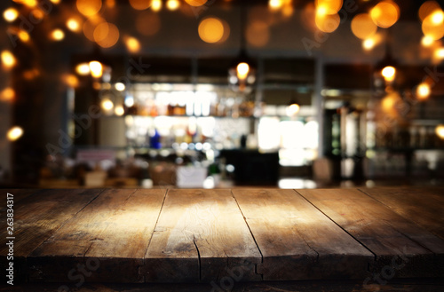 mage of wooden table in front of abstract blurred restaurant lights background