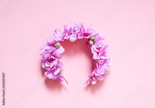 Artificial decorative wreath of purple flowers on pink background with copy space © pictures_for_you