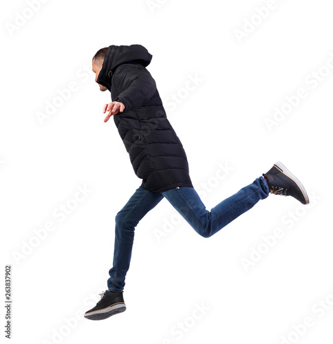 Side view of a man in a winter jacket who jumps.