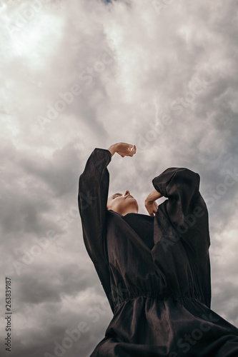 Person dancing under cloudy sky photo