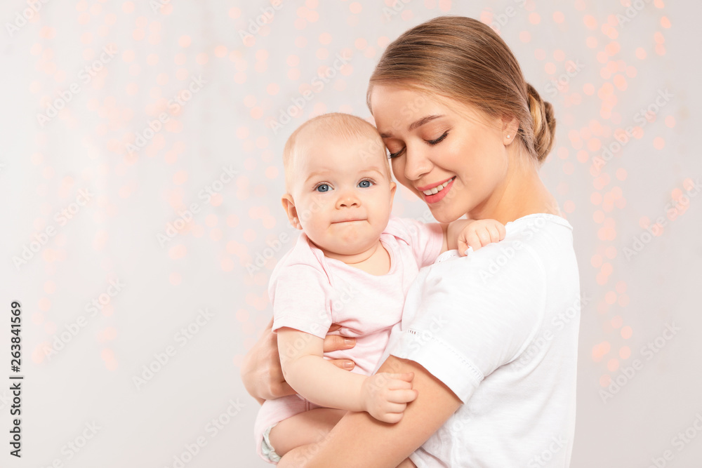 Portrait of happy mother with her baby against blurred lights. Space for text Portrait of happy mother with her baby against blurred lights. Space for text