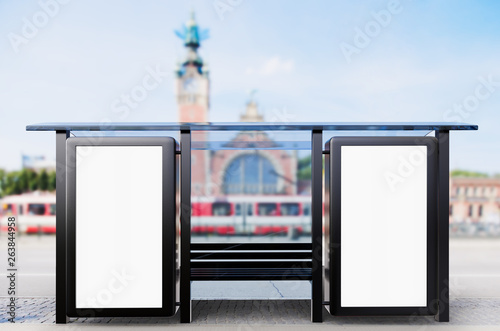 Bus stop with empty advert (billboard) with city background 