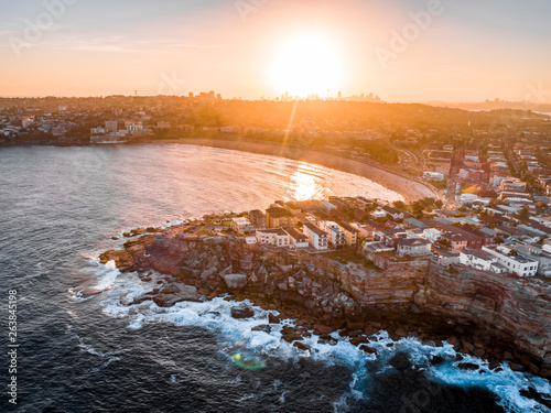 Bondi Beach Drone Shot at Sunset with Sydney CBD in background at Sunset