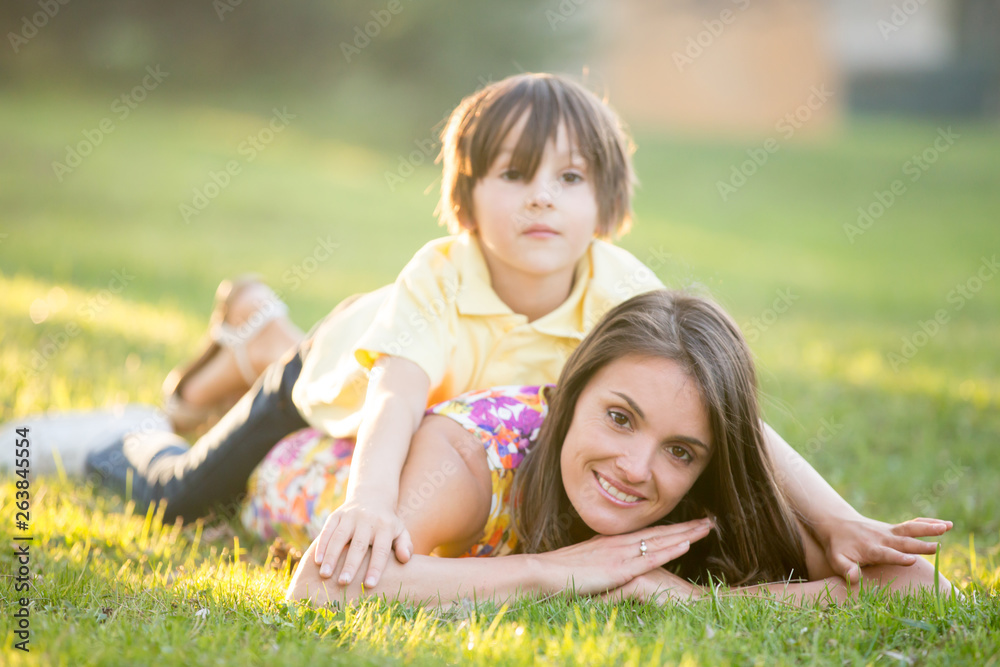 Beautiful family, mother, father and three kids, boys, having familly outdoors portrait taken on a sunny spring evening, beautiful blooming garden, sunset time Beautiful family, mother, father and three kids, boys, having familly outdoors portrait taken on a sunny spring evening, beautiful blooming garden, sunset time