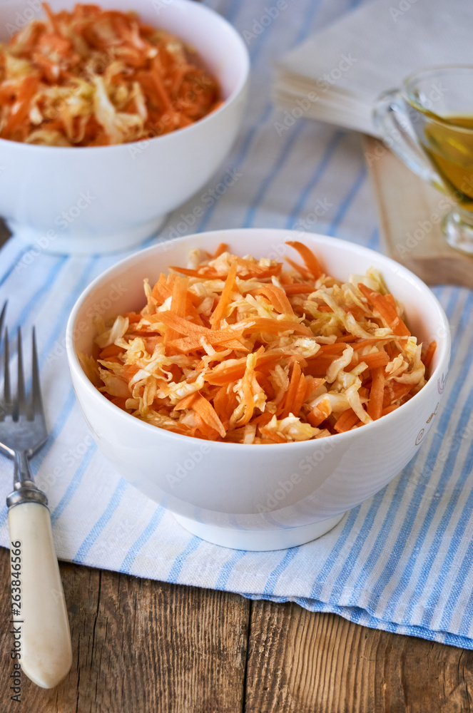 Salad with fresh cabbage, carrots and olive oil in a white bowl Salad with fresh cabbage, carrots and olive oil in a white bowl