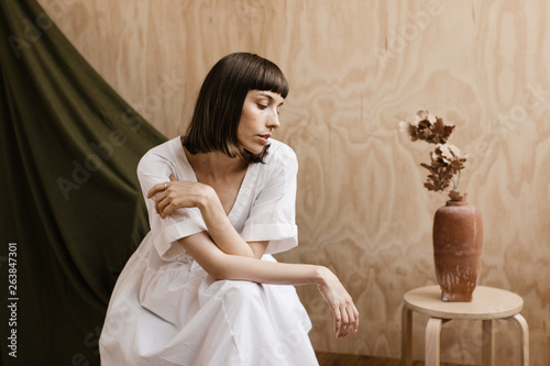 modern creative portrait of brunette woman in front of plywood and fabric backdrops