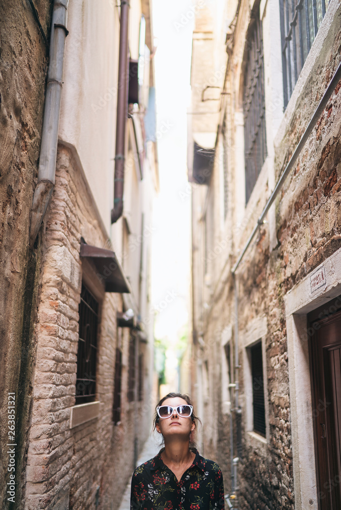 Woman tourist travel in Italy. Young girl on an old street, Venice