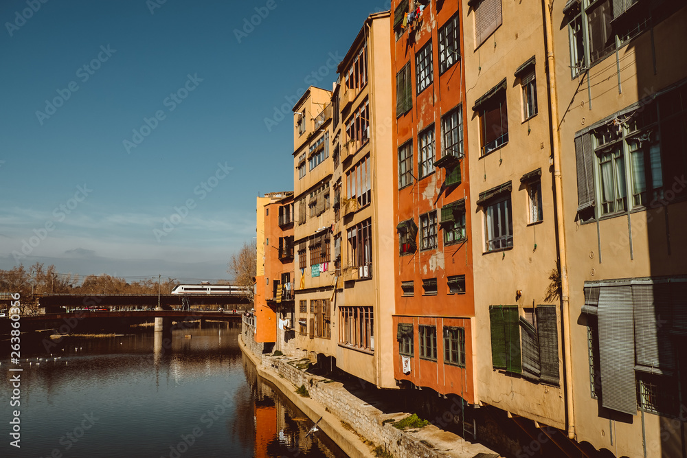 Colorful yellow and orange houses and famous house Casa Maso reflected in water river Onyar