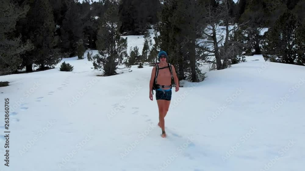 Man walks through snow forest in just underwear, training Wim Hof meditation style conditioning Man walks through snow forest in just underwear, training Wim Hof meditation style conditioning