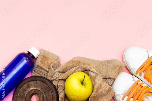 ports equipment flat lay, old metal dumbbells and apples, water bottle and brown towel, sneakers sport. Concept healthy lifestyle, sport and diet.