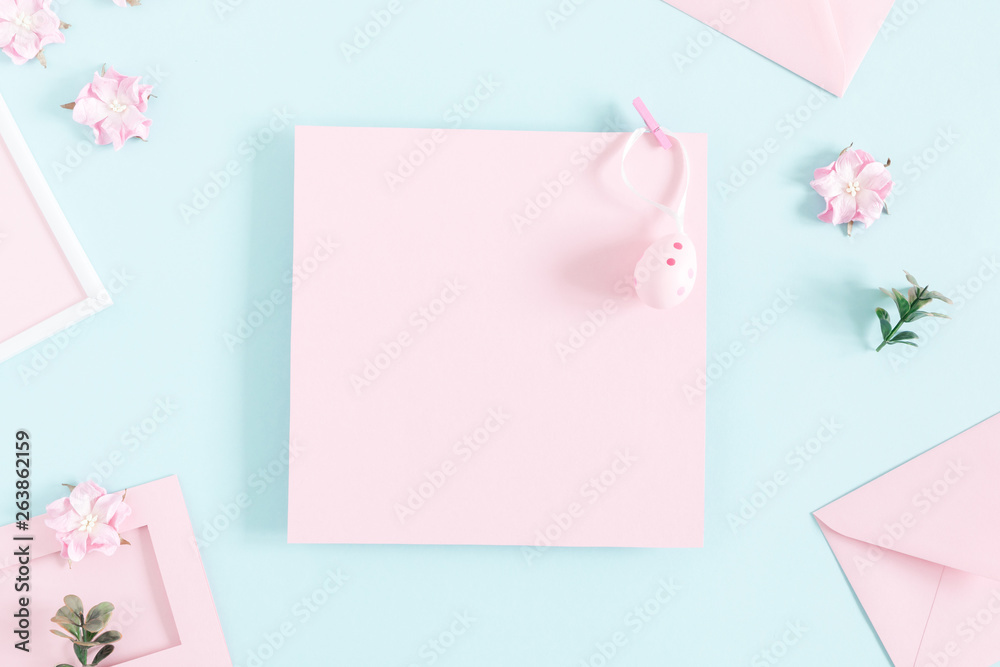 Easter decor, composition. Flowers, easter egg, senvelopes, decorations on pastel blue background. Flat lay, top view, copy space