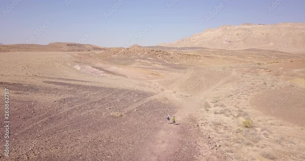 Aerial wide shot of hikers walking in the middle of the Negev Desert, Israel Aerial wide shot of hikers walking in the middle of the Negev Desert, Israel