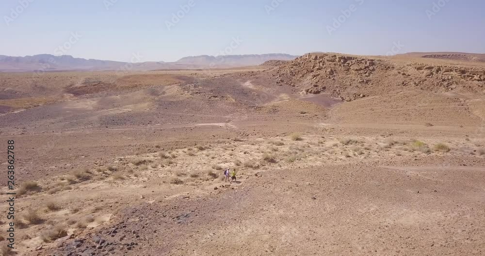Dolly aerial wide shot of hikers walking in the middle of the Negev Desert, Israel 02 Dolly aerial wide shot of hikers walking in the middle of the Negev Desert, Israel 02