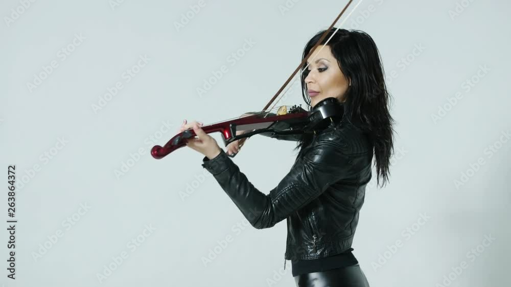 slender sensual artistic young Asian girl in tight black leather clothes expressively plays the electric violin slender sensual artistic young Asian girl in tight black leather clothes expressively plays the electric violin
