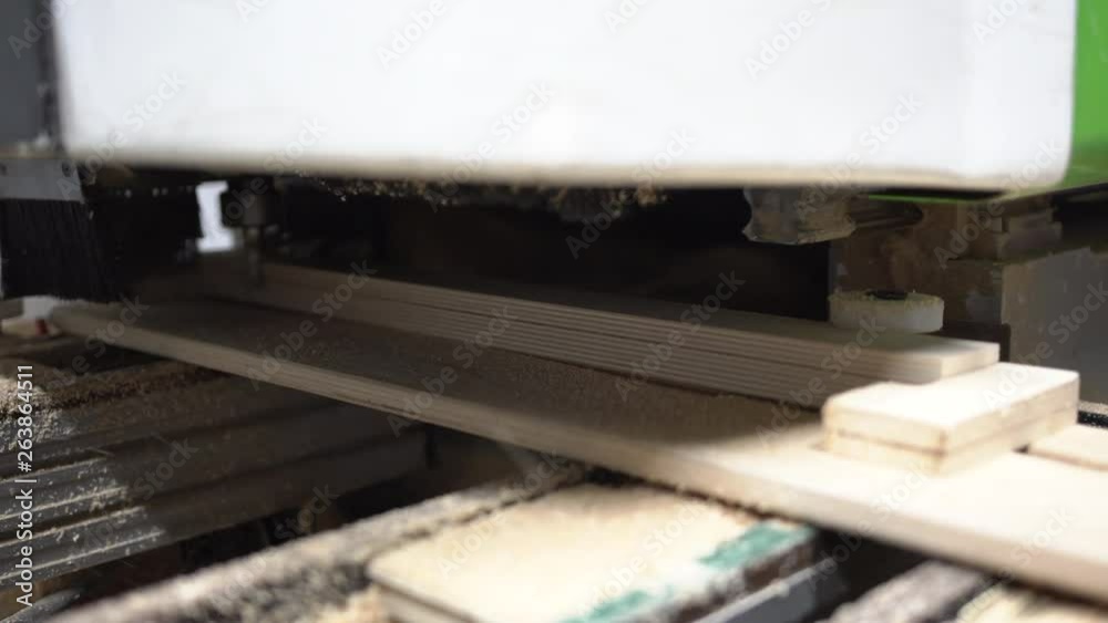 Technical CNC machine mills to the right and back to the left element of plywood using diamond cutter, producing a lot of sawdust. Operator dismounts finished part. Technical CNC machine mills to the right and back to the left element of plywood using diamond cutter, producing a lot of sawdust. Operator dismounts finished part.