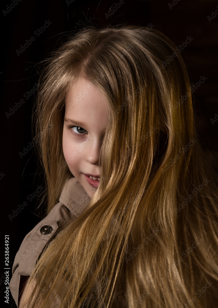 Naklejka premium beautiful lovely little blonde girl with different emotions on a dark background