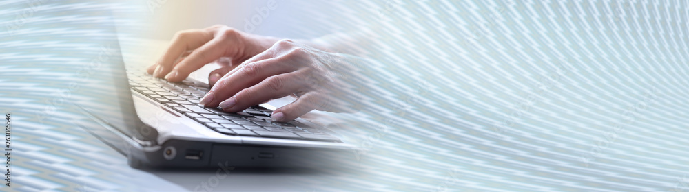 Hands typing on a laptop keyboard, light effect. panoramic banner Hands typing on a laptop keyboard, light effect. panoramic banner