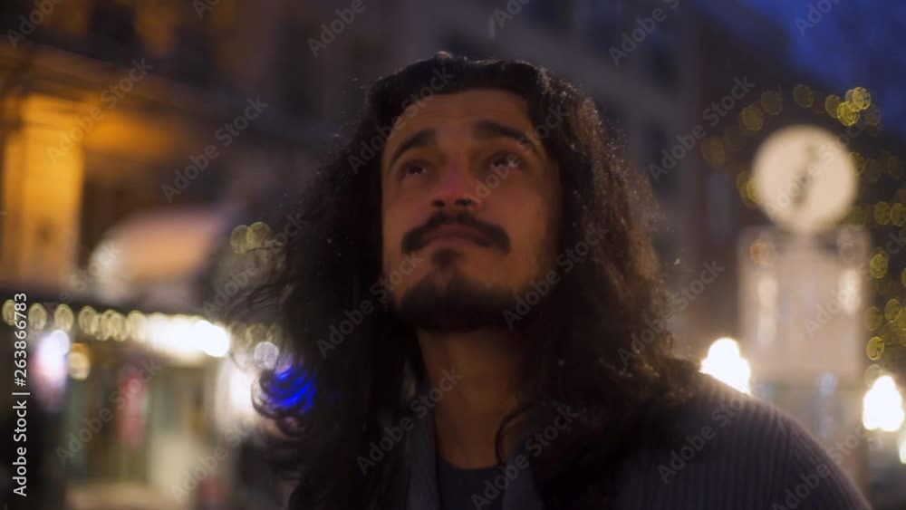 CLOSEUP REVERSE TRACKING SHOT of Indian Man Walking Through Snowy Nighttime City Scene CLOSEUP REVERSE TRACKING SHOT of Indian Man Walking Through Snowy Nighttime City Scene