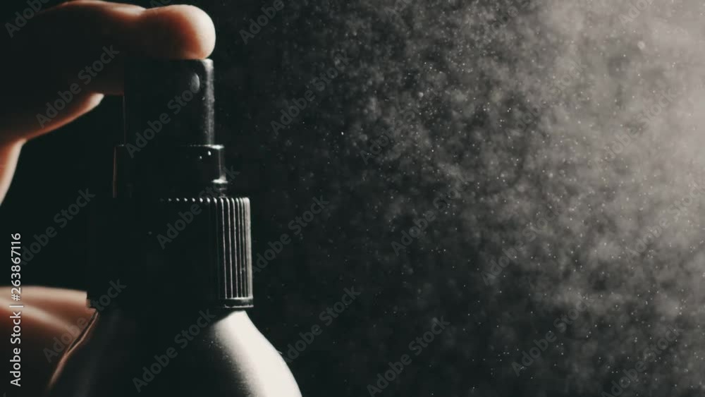 Spraying water against dark background, super slow motion close-up