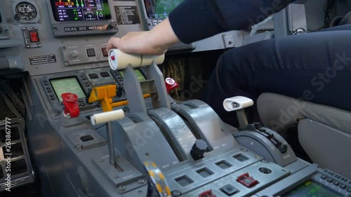 Close Up of Throttle Unit in Cockpit of Regional Airplane Taking Off at Airport With Hand of Pilot and Other Instruments. photo