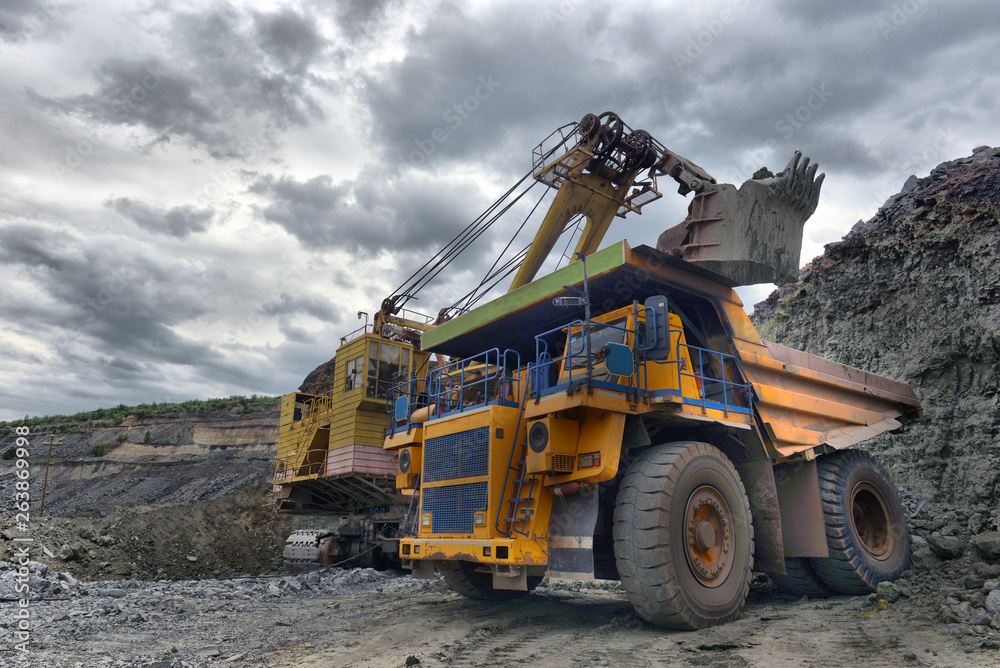Large quarry dump truck. Loading the rock in the dumper. Loading coal into body work truck Large quarry dump truck. Loading the rock in the dumper. Loading coal into body work truck