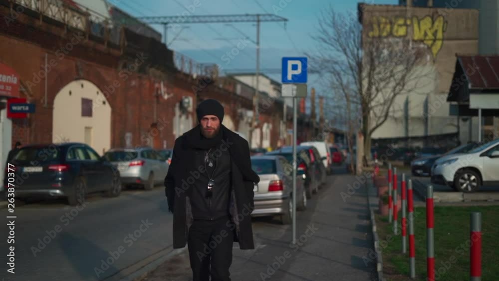 A Slow Motion Shot of Man Dressed in All Black Walking Along an Overpass With Train Going By in Background A Slow Motion Shot of Man Dressed in All Black Walking Along an Overpass With Train Going By in Background