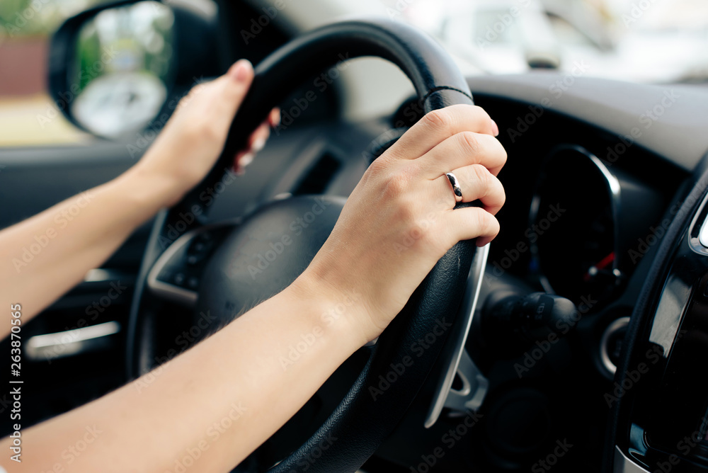 girl's hands on the wheel of a car
