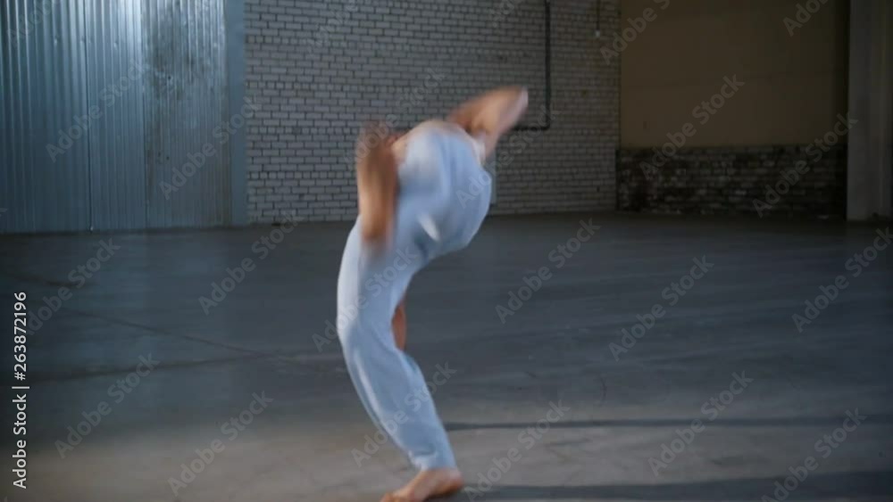 A man training his skills. Performing capoeira elements with standing on hands