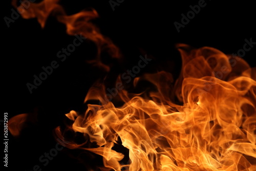 Fire burning on dark background for abstract flame texture and graphic design purpose © Akarawut