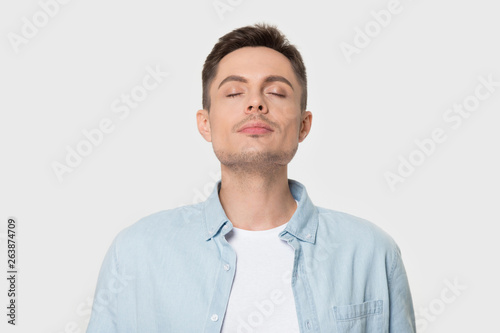 Calm Caucasian man breath deep enjoying pleasant smell photo
