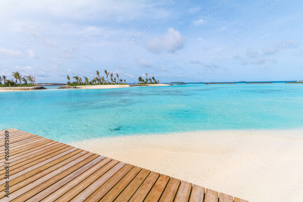 Amazing island in the Maldives ,wooden bridge and  beautiful  turquoise waters with  blue sky  background for holiday vacation .