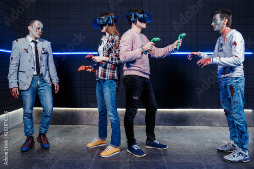young guy and girl and zombies in a virtual reality club