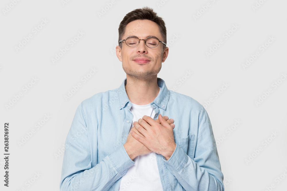Grateful Caucasian man in glasses isolated on grey background Grateful Caucasian man in glasses isolated on grey background