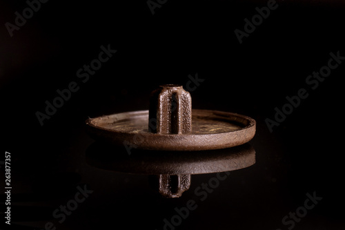 One whole brown plast masking plug work item isolated on black glass