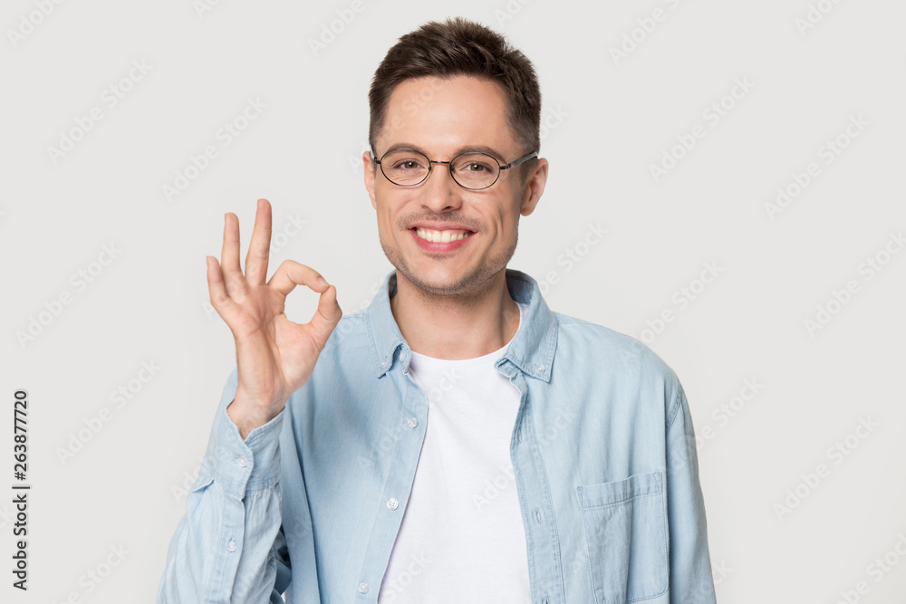 Smiling man in glasses show ok sign isolated in studio Smiling man in glasses show ok sign isolated in studio