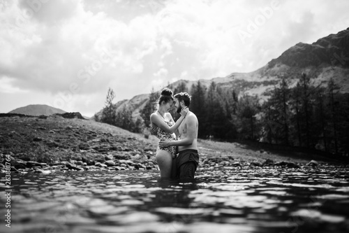 Black and white photo of man and woman embracing in the water