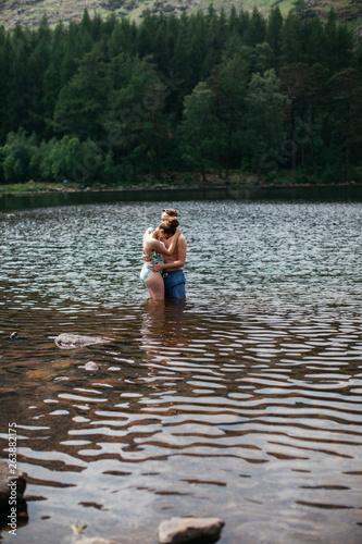 Couple embracing from far away in a lake